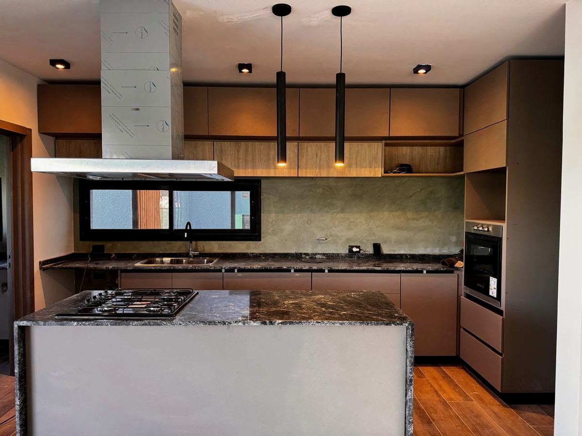 Cocina con isla, madera y luz colgante